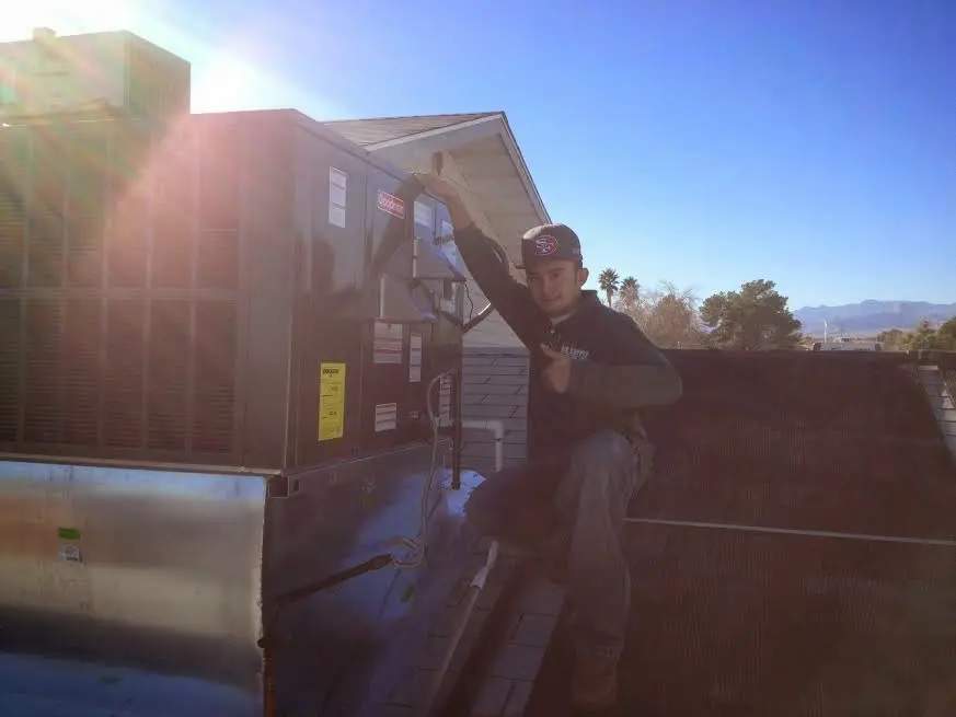 HVAC technician performing Heat Pump Repair on a rooftop unit in Fairview